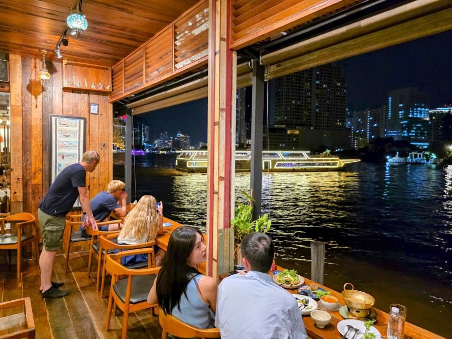 Restaurant au bord du fleuve, bateau illuminé la nuit