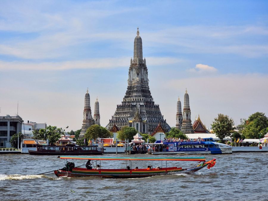 Temple Wat Arun et bateau traditionnel sur le fleuve Chao Phraya