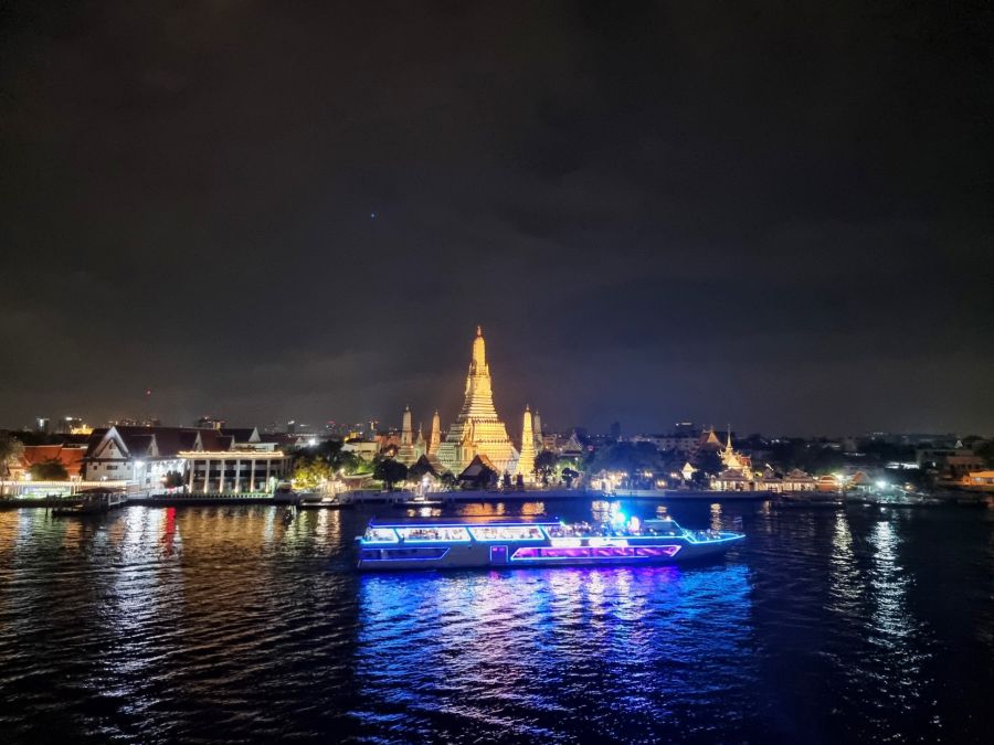 Bateau illuminé devant le temple Wat Arun à Bangkok, nuit