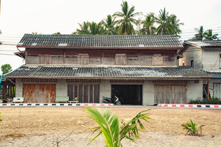 Old wooden house surrounded by palm trees