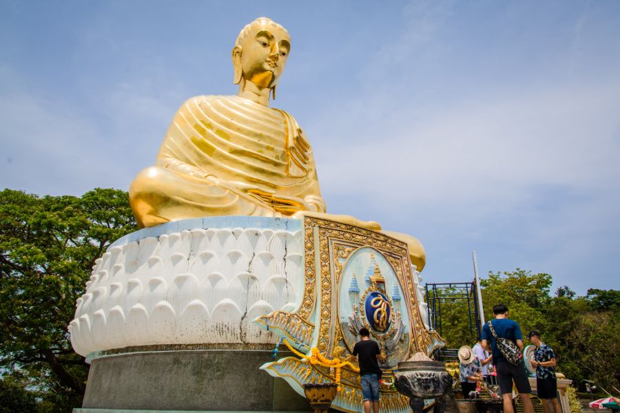 Golden Buddha statue surrounded by visitors