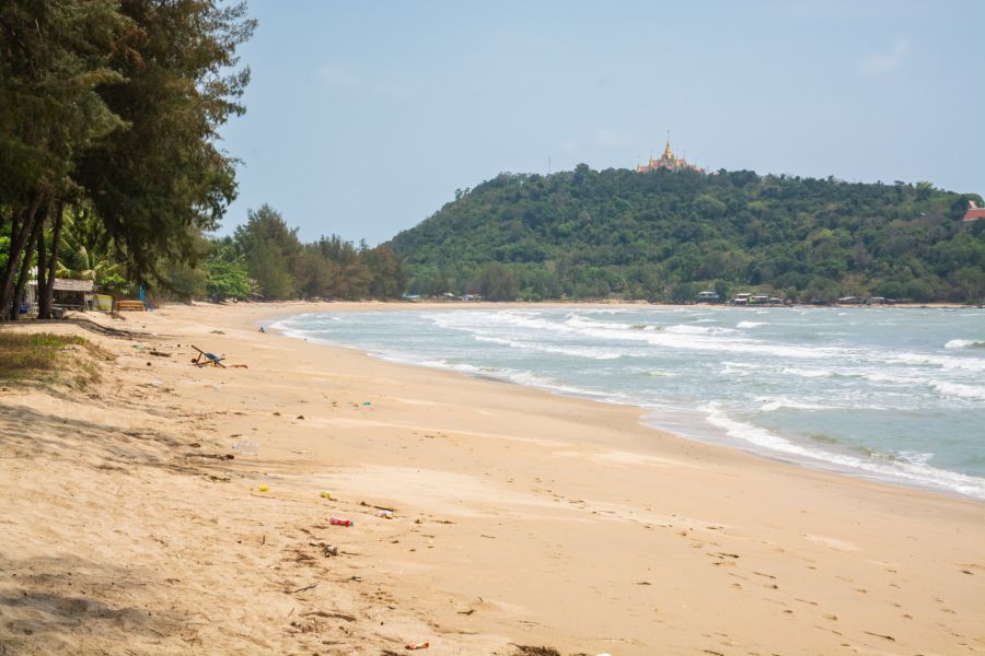 Tree-lined beach, wooded hill and golden temple