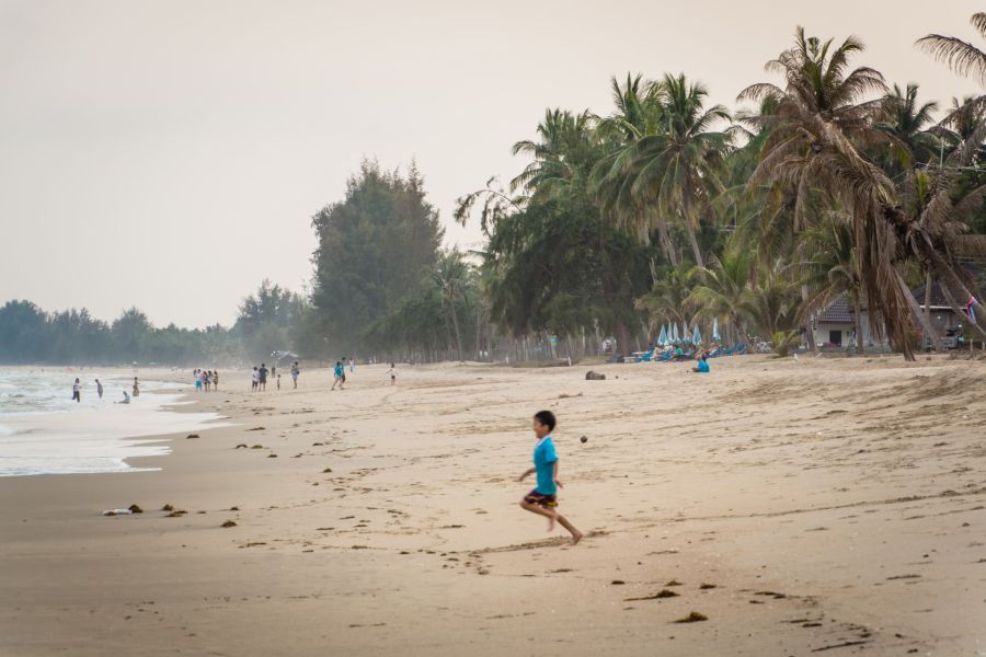 Child running on a palm-fringed beach