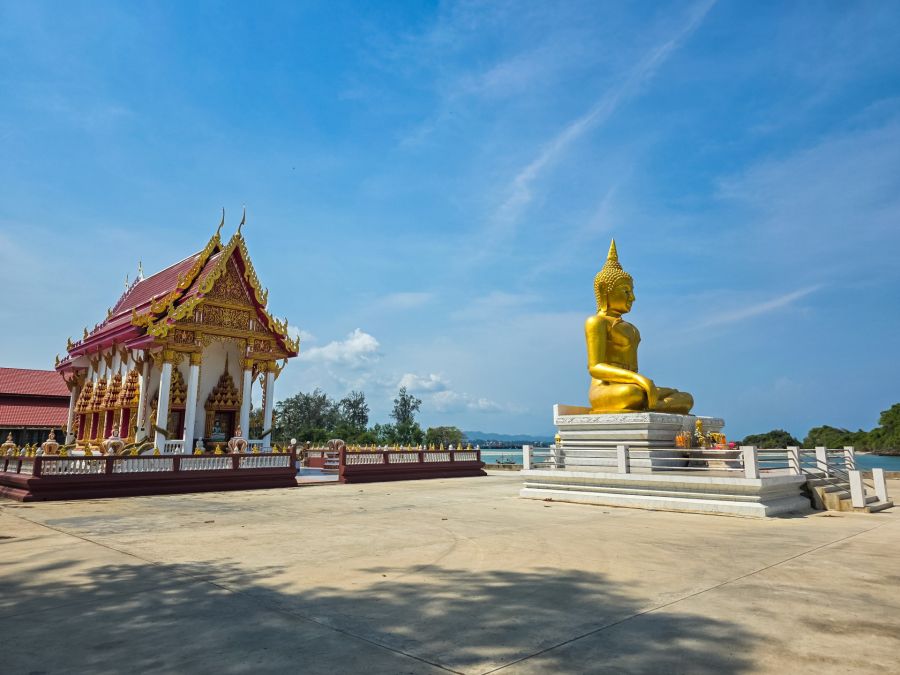 Golden Buddha statue in front of a Thai temple