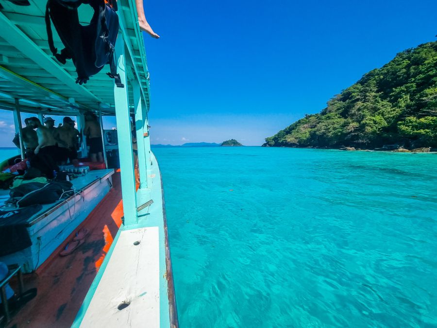 Bateau de plongée naviguant sur une mer turquoise près d’une île