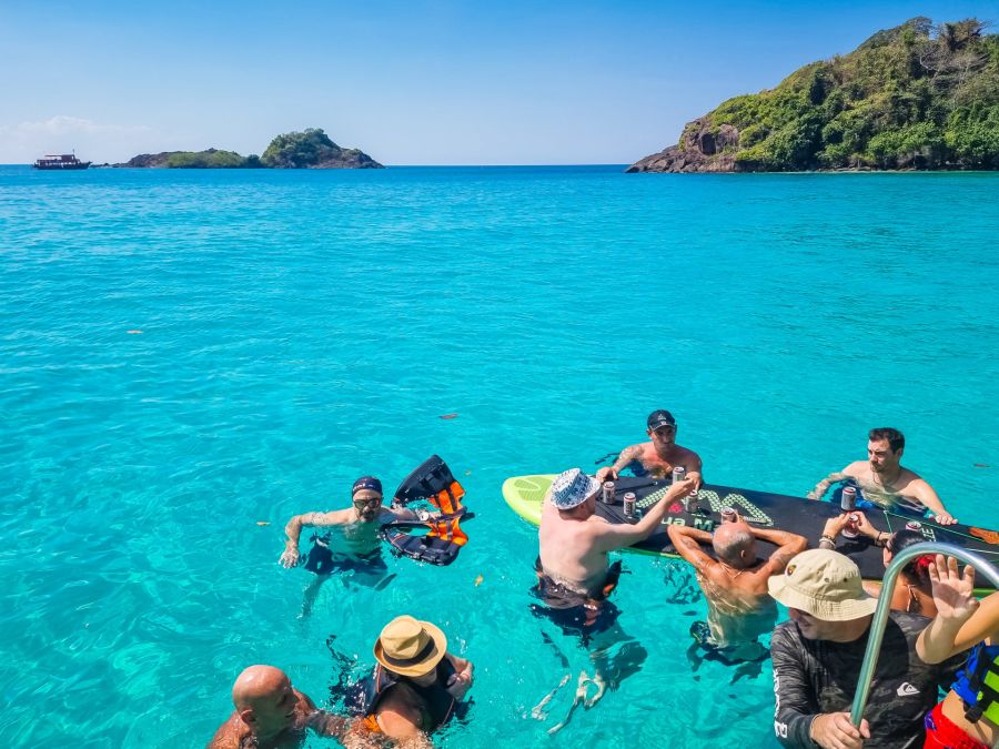 Groupe d’amis flottant dans une mer turquoise près d’îlots