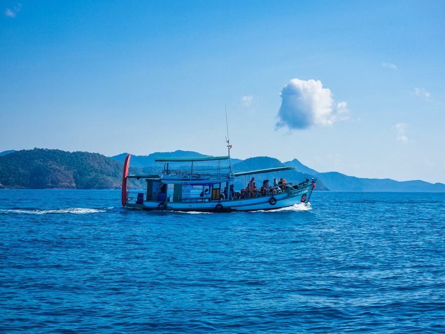 Bateau touristique naviguant devant des îles montagneuses