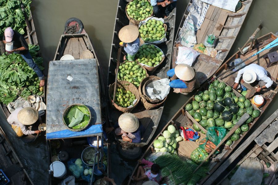 Marché flottant avec barques chargées de fruits et légumes