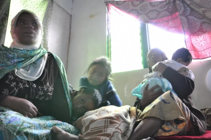 family sheltering rain Dieng plateau Java Island