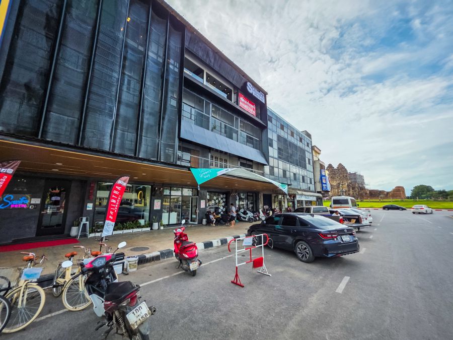 Hôtel urbain près d’un temple ancien avec véhicules garés