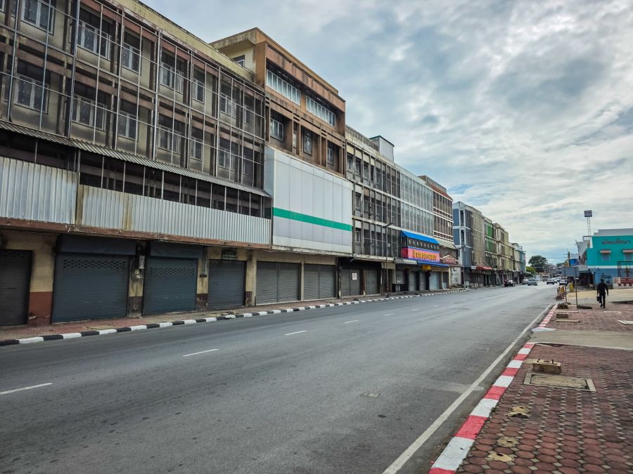 Rue calme bordée d’immeubles commerciaux aux rideaux baissés