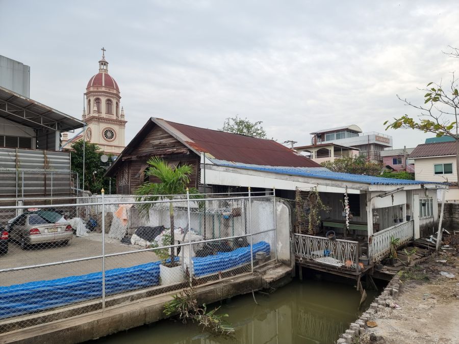 Maisons au bord d’un canal, clocher d’église en arrière-plan