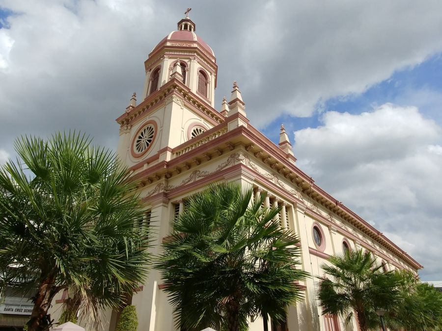 Église néoclassique avec clocher rose et palmiers