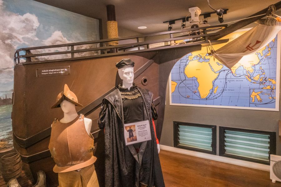 Mannequins portugais devant maquette de navire et carte maritime