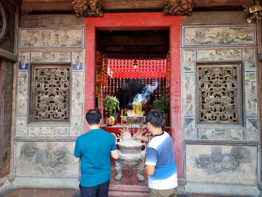Deux hommes prient devant un autel de temple chinois