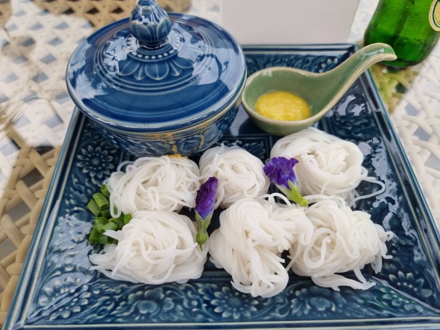 Nouilles de riz sur plateau bleu avec sauce jaune