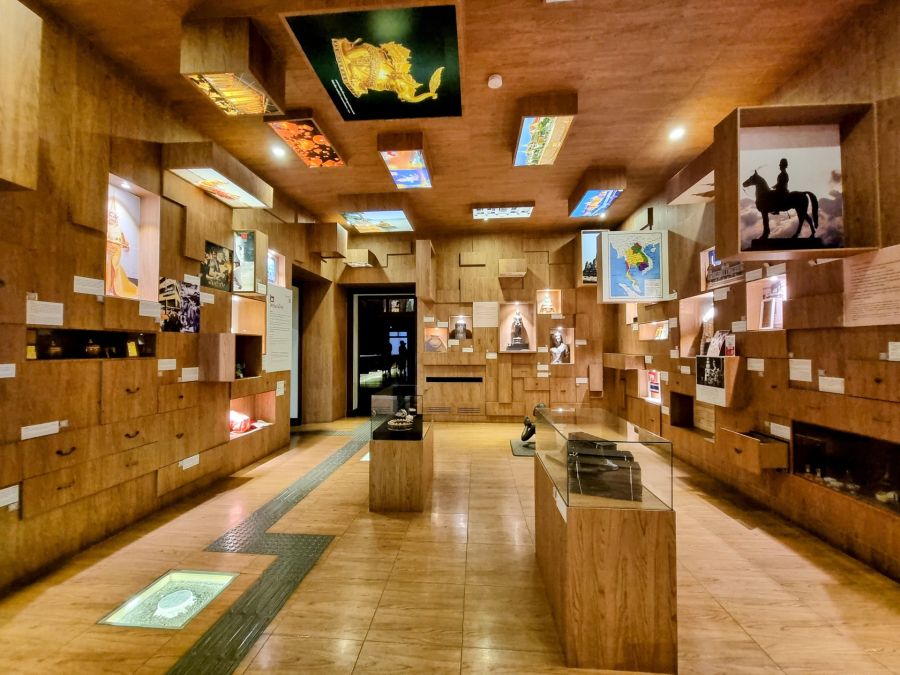 Salle de musée en bois avec vitrines et expositions historiques
