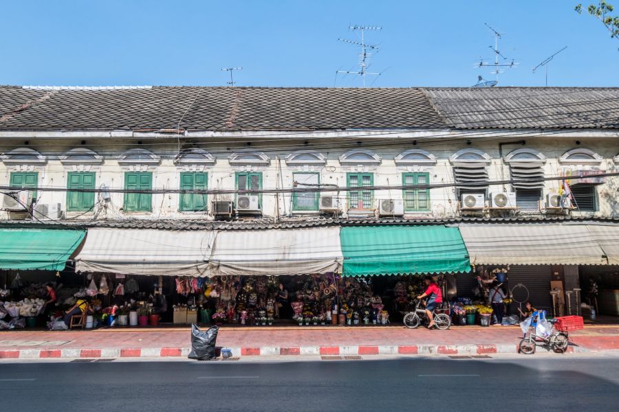 Marché aux fleurs devant un immeuble ancien aux volets verts