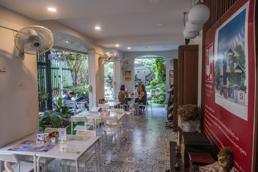 Intérieur de café lumineux avec tables, clients et plantes