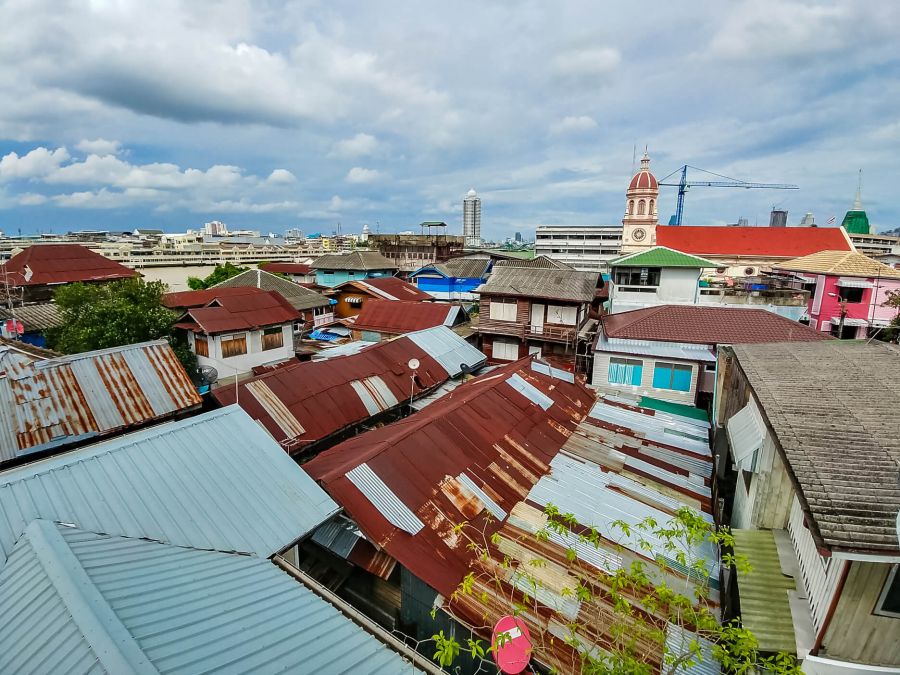 vue depuis les toits droite baan kudee jin museum bangkok Toits urbains, église et gratte-ciels sous ciel nuageux
