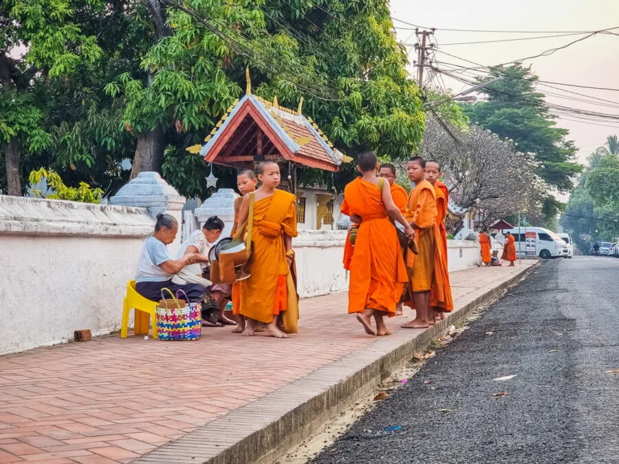 locals offering alms monks luang prabang