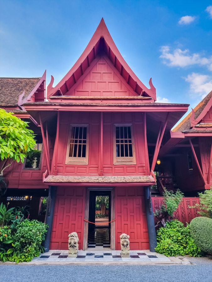 Maison traditionnelle rouge à toit pointu sous ciel bleu