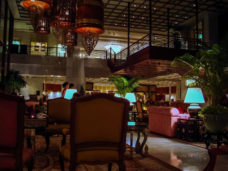 Hall d’hôtel luxueux avec fauteuils, lampes et escalier