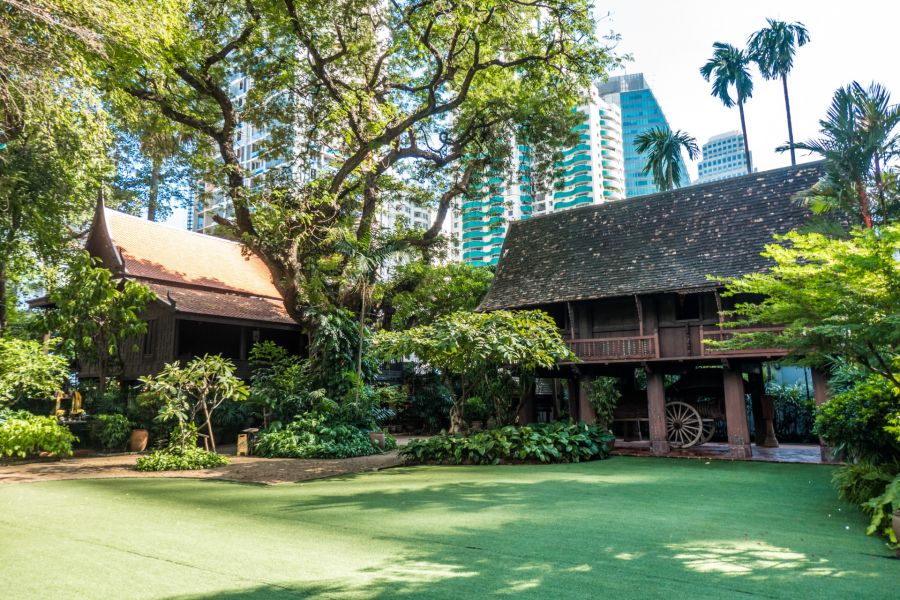 Maisons traditionnelles dans un jardin, entourées de gratte-ciel