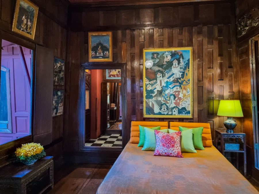 Chambre boisée avec lit coloré, tableaux et lampe verte