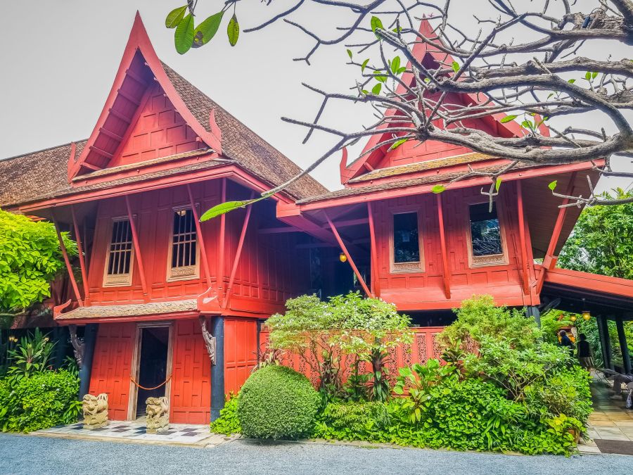 Maison traditionnelle rouge entourée de végétation tropicale