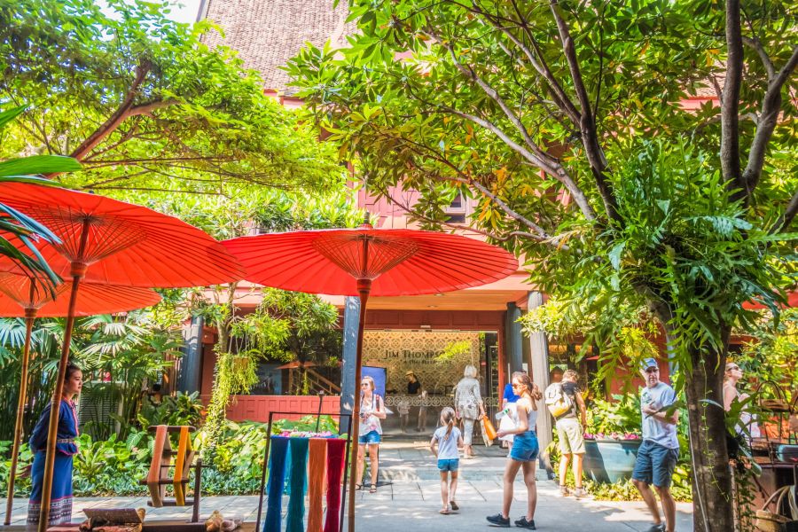 Parapluies rouges dans un jardin tropical avec visiteurs