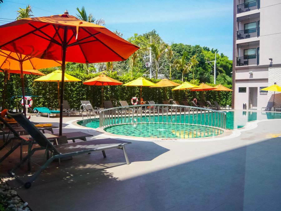 Piscine d’hôtel avec parasols colorés et transats