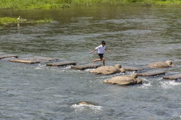 child crossing kamo river kyoto