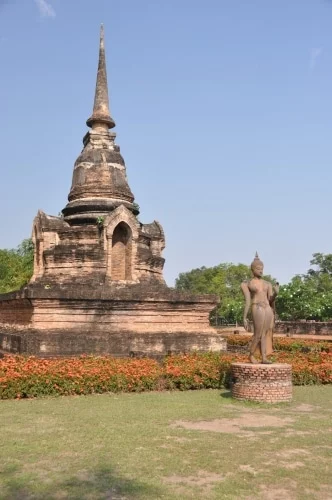 chedi and walking buddha statue wat sa si sukhothai