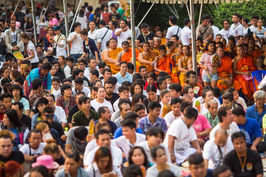Foule rassemblée avec des moines bouddhistes en robes orange
