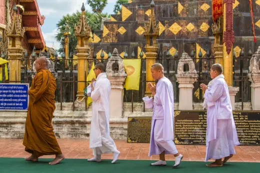 monk and nuns praying around the chedi wat phra that lampang luang