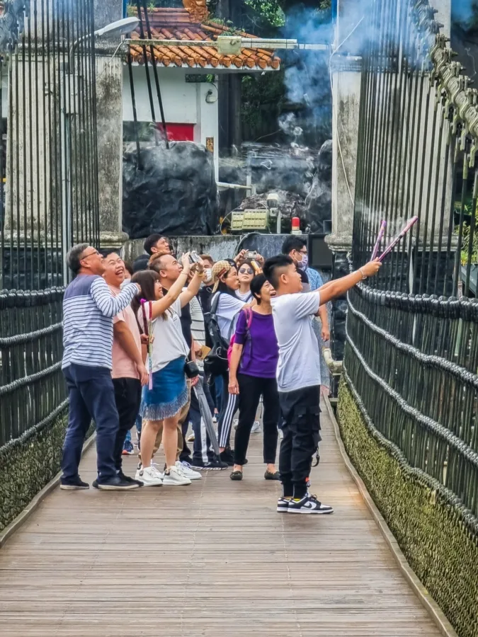 Locals lighting small fireworks on Shifen suspension bridge