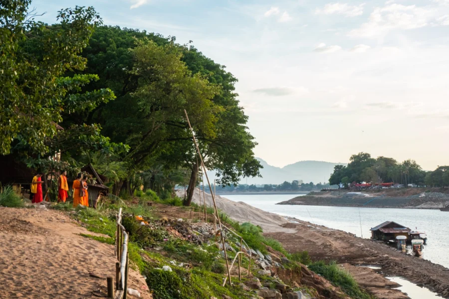 monks on the shore at Wat Luang Pakxe, Laos