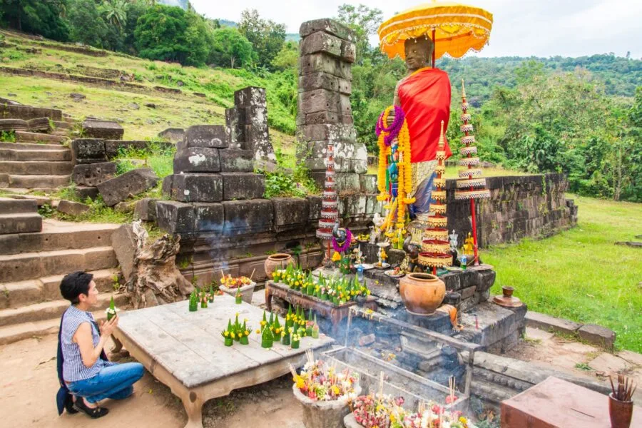 prayer in front of the statue of the staircase of Vat Phou Champassak