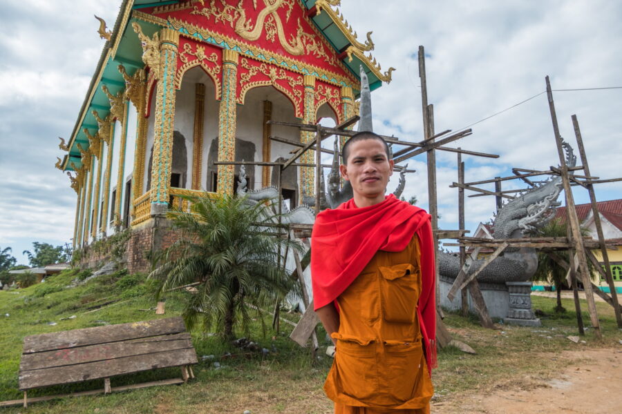 moine posant devant temple paksong laos