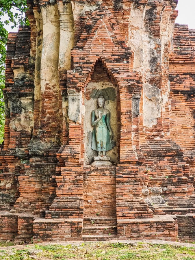 statue de bouddha dans niche chedi du wat mahathat ayutthaya
