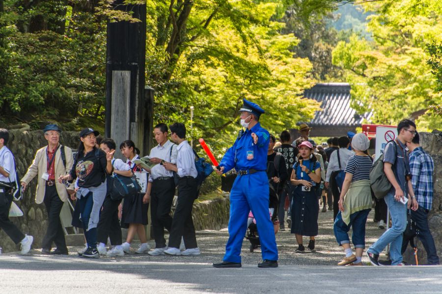 municipal officer helping cross road Kyoto Japan
