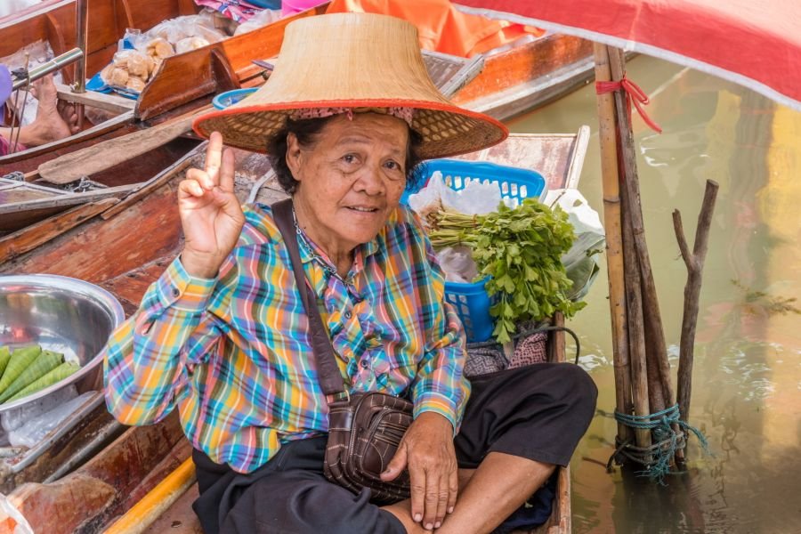 vendeuse saluant au marché flottant de tha kha thailande